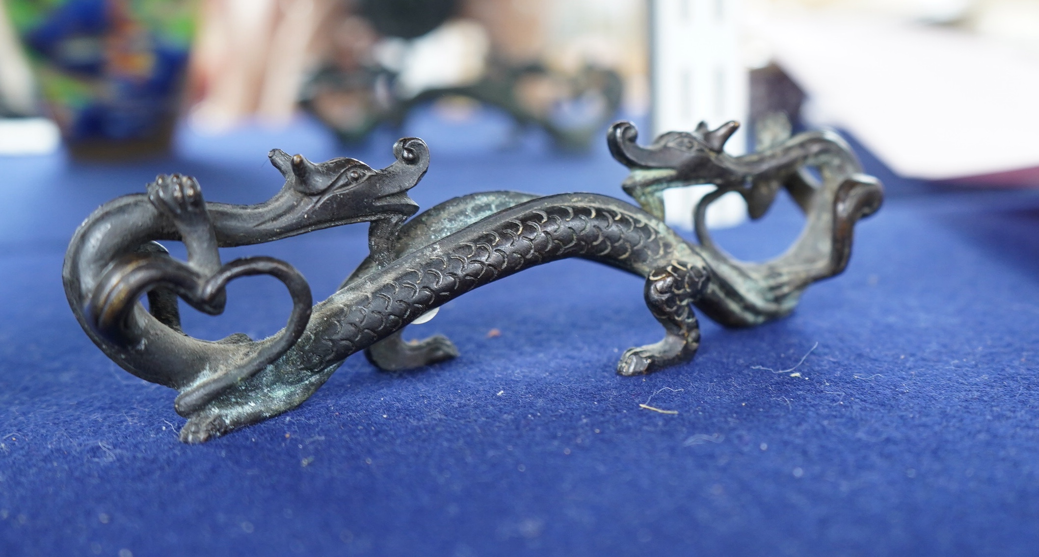 A Chinese bronze brush rest modelled as two dragons, 17cm wide. Condition - good